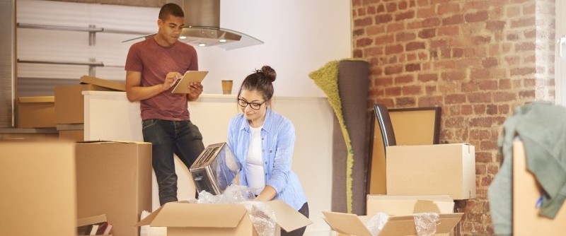 a couple is packing for a move