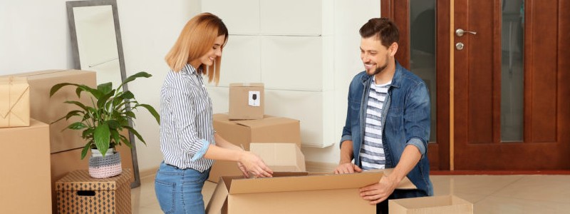 young couple packing a cardboard box