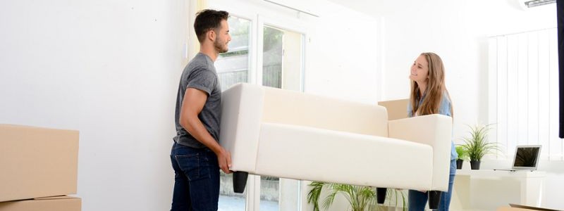 Young couple trying to relocate a couch