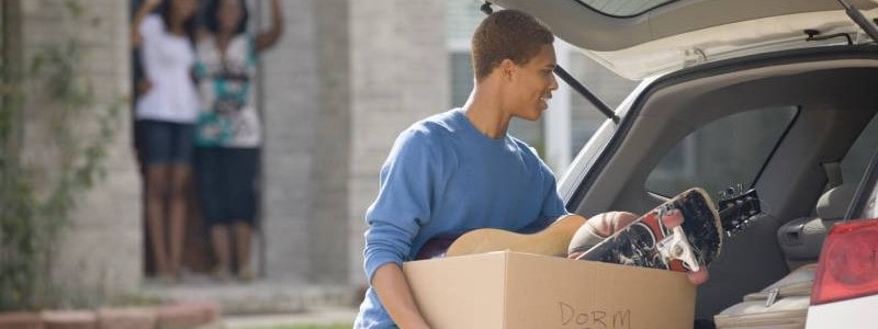 young man putting the household on a car