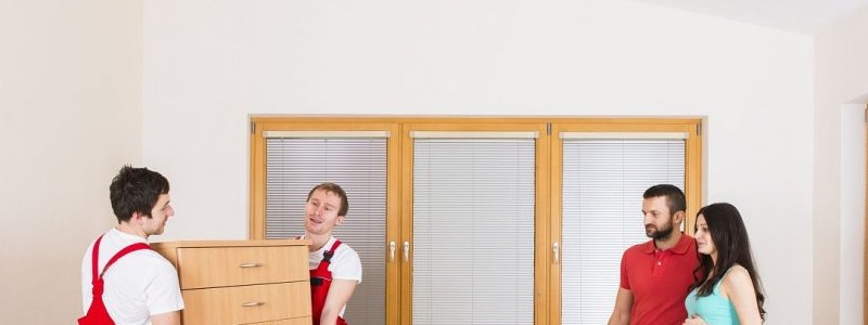 young couple standing inside of a house with professionals