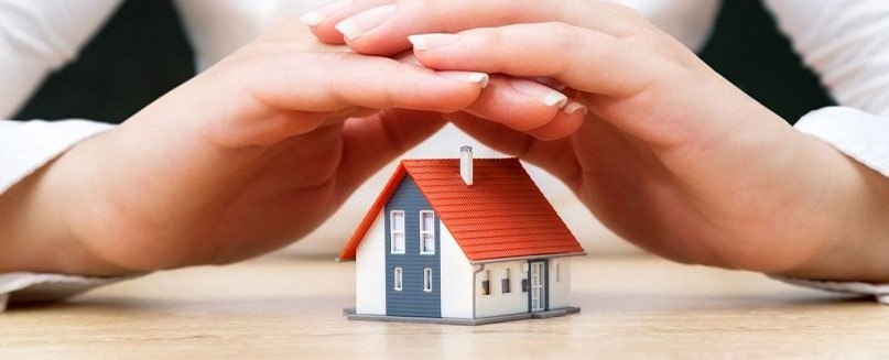 cropped picture of a person covering a dummy house with hands
