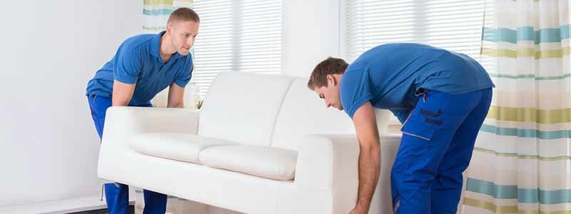 young professionals trying to lift a heavy couch