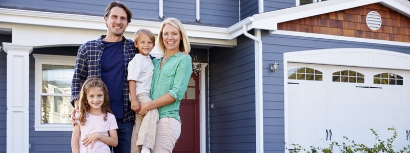 family standing outside of their new house