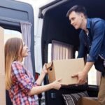 young woman and young man loading a truck