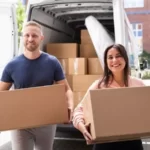 couple with cardboard boxes loading a truck