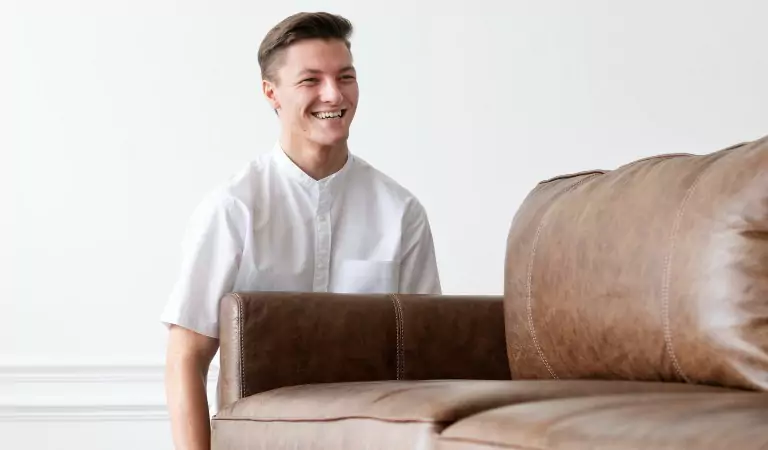 young man holding heavy couch