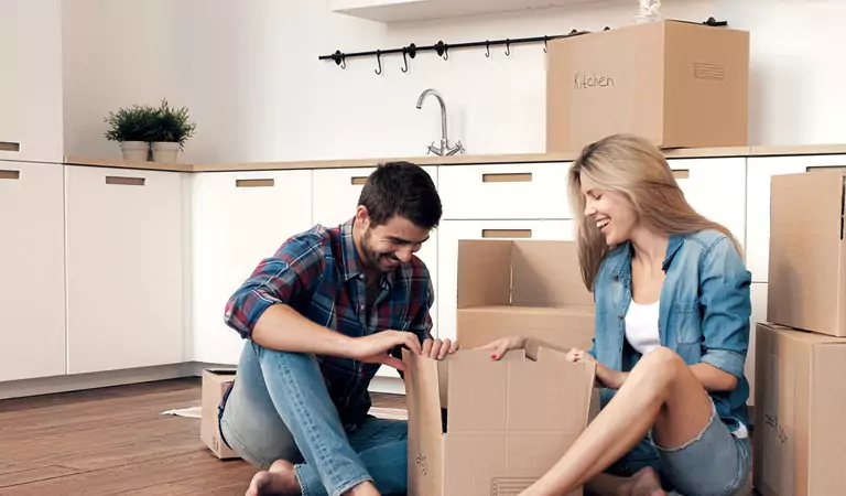 couple sitting on the floor inside of a houe