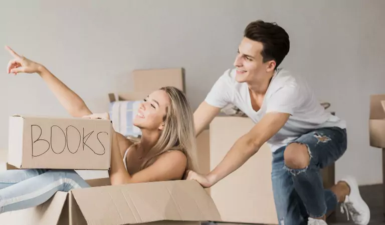 young woman sitting inside a moving mox and a person pushing it from the back