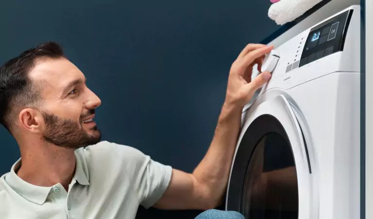 young man switching on a washing machine