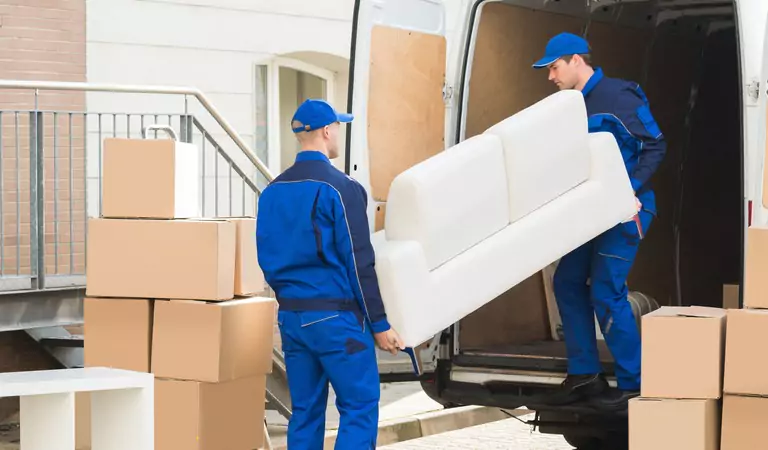 young professionals holding a heavy couch to load into a truck