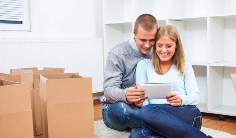 couple inside of a new house sitting on a floor