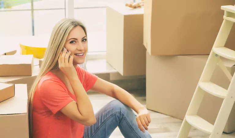 young woman talking on a call and some boxes at the back