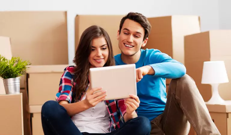couple sitting on the floor and searching something on a tablet