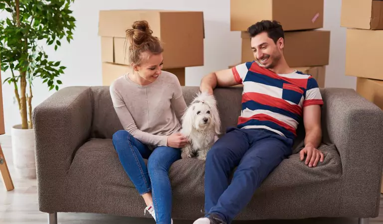 couple with their pet inside of a house