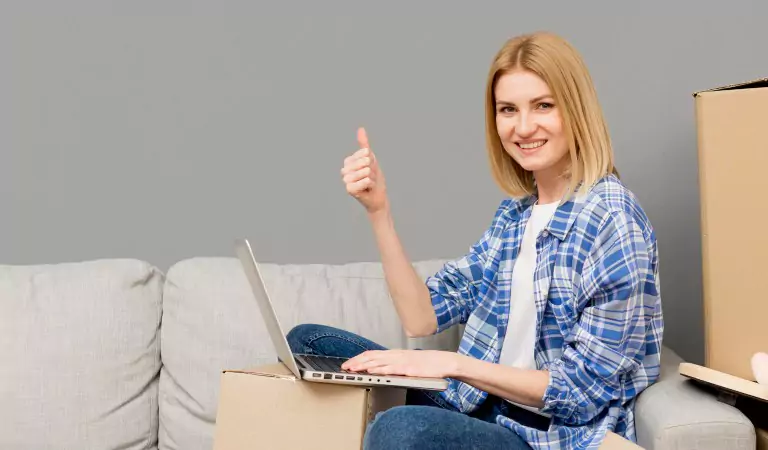 young woman working on a laptop and showing thumb is up