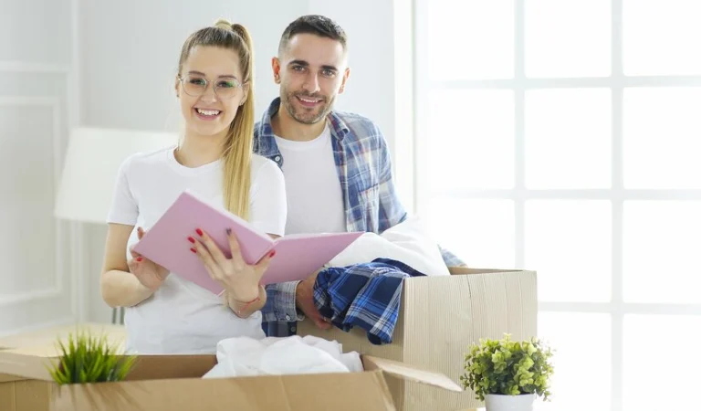 Woman in white top holding a book in her hand and a man in check shirt