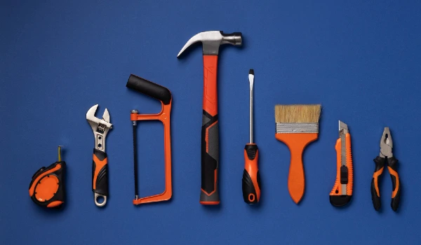 Top view of steel hammer with other construction elements and tools